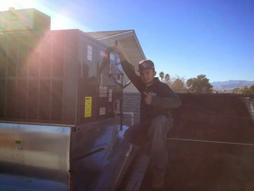 HVAC technician performing AC Tune-Up on a rooftop unit in Garrett